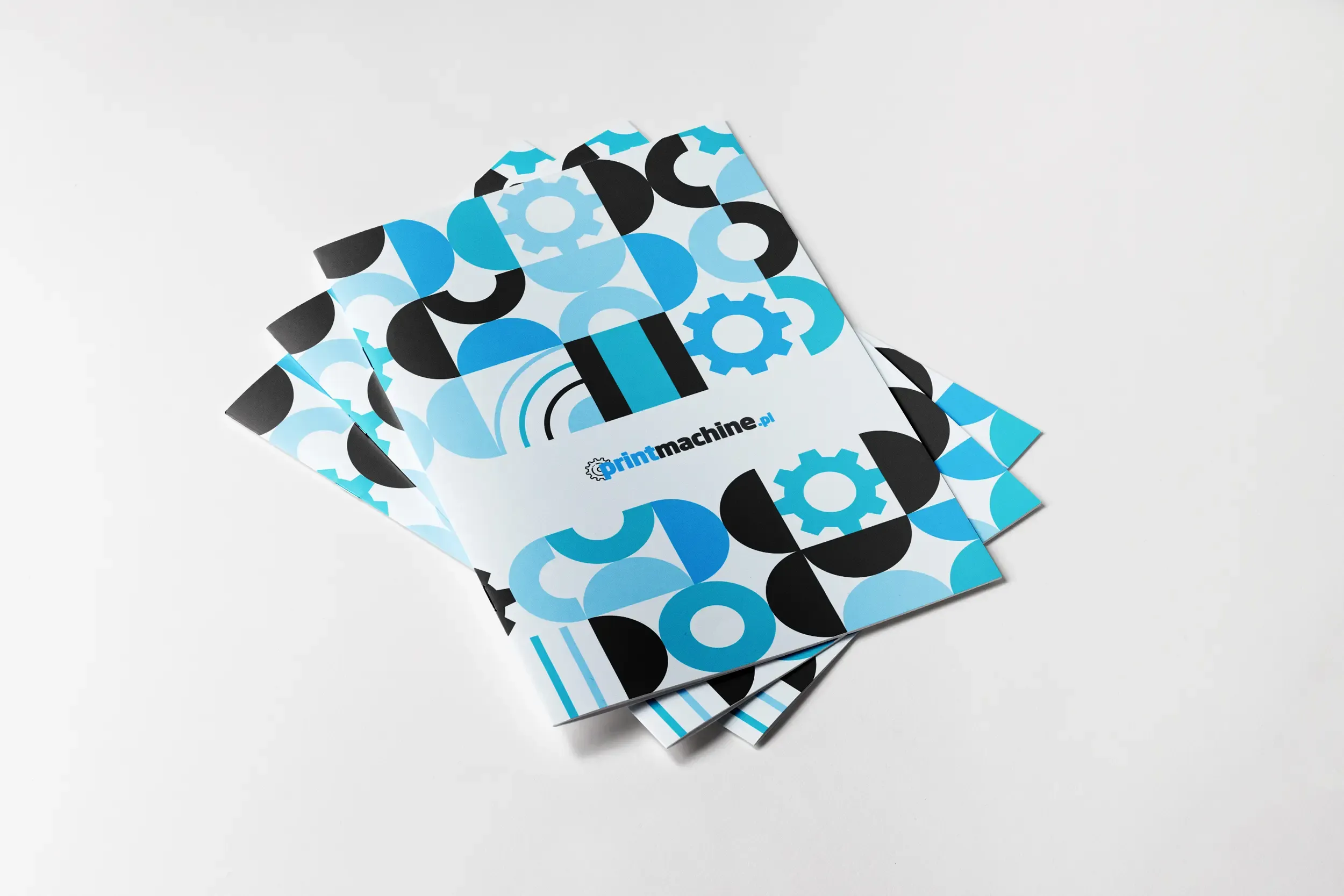 Gazetka reklamowa szyta z pełnokolorową okładką ułożona na tle dwóch egzemplarzy. Mockup prezentuje estetyczny wygląd, zszywany grzbiet oraz wysoką jakość druku materiałów promocyjnych.